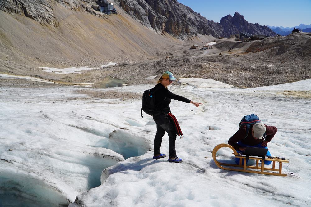 A Ryme team member taking measurements beside a glacier crevasse on Zugspitze